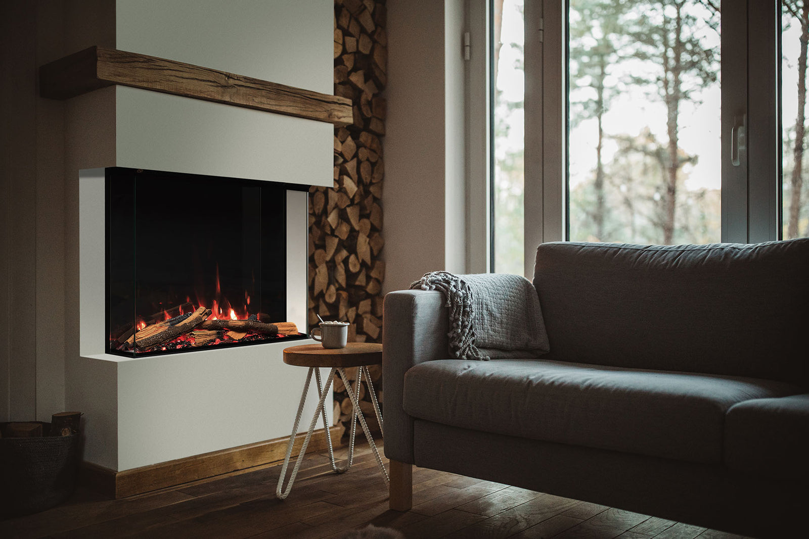 Solus VS75 electric fire with glass sides beneath a wooden mantel beside a log store