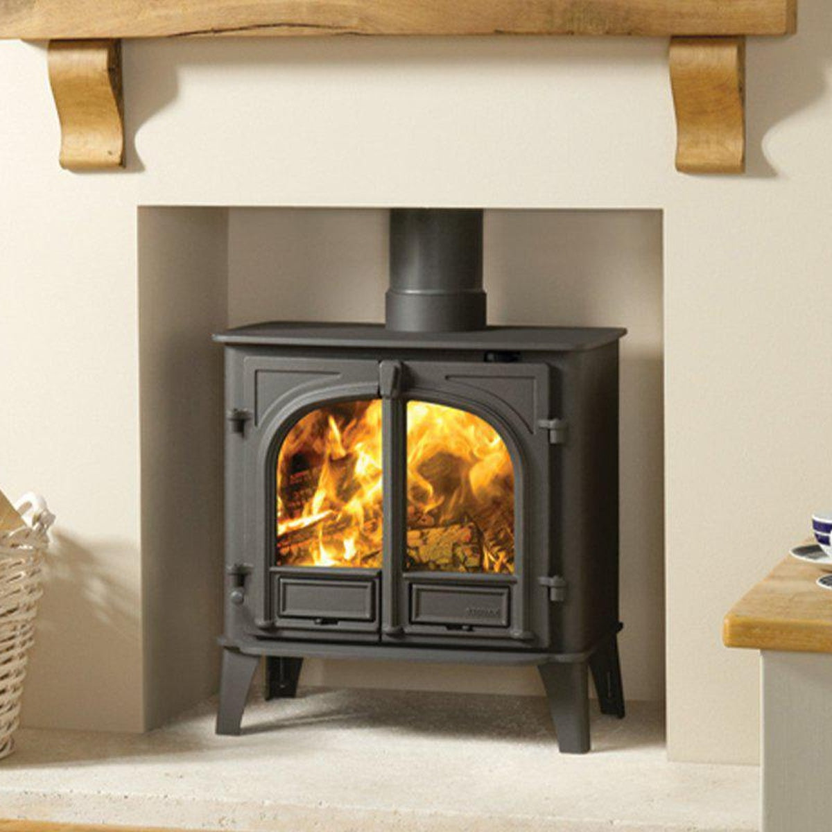 Stovax Stockton 8 Matt Black double-door multi-fuel stove beneath a limestone shelf