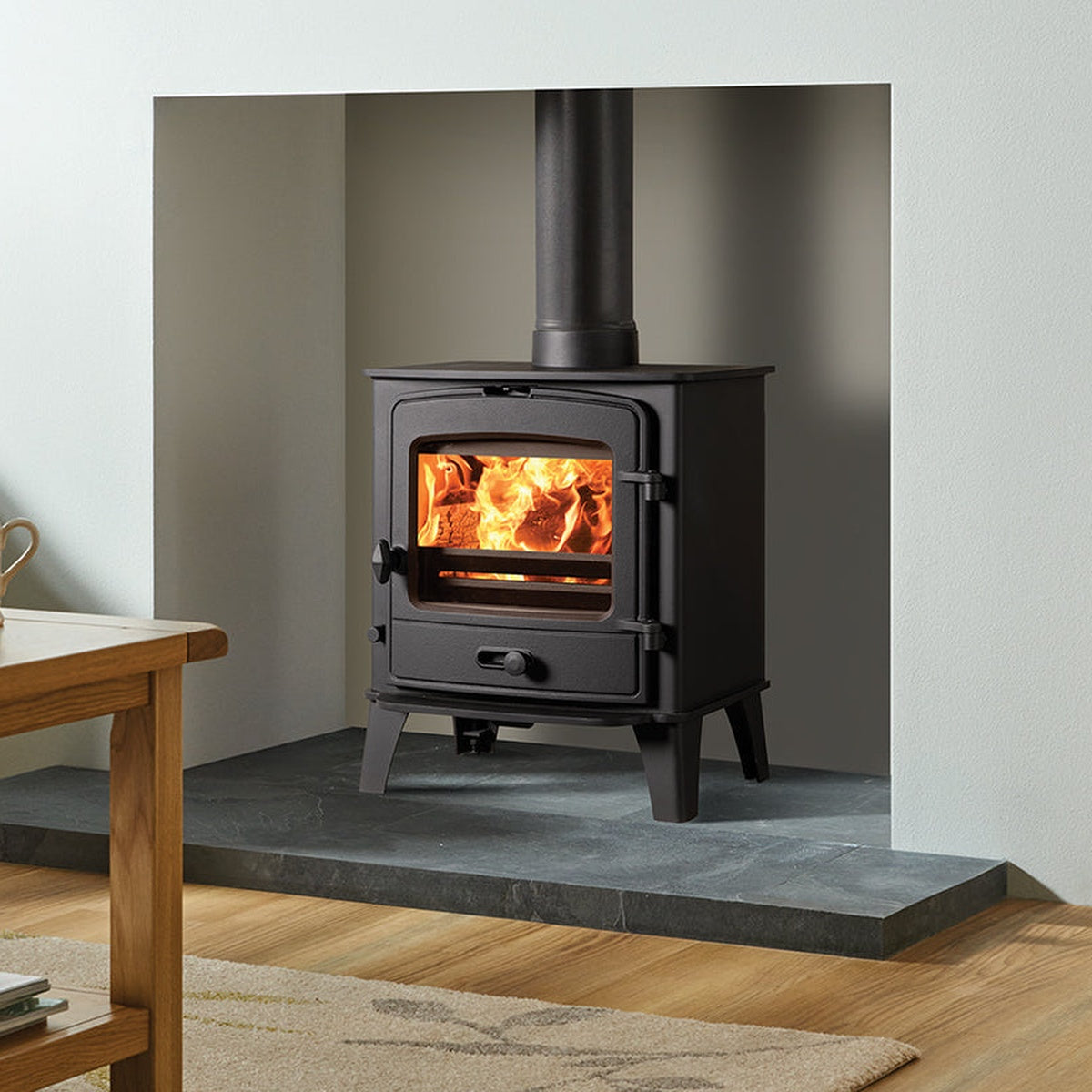 Stovax County 5 stove in a grey recess beside a wooden table