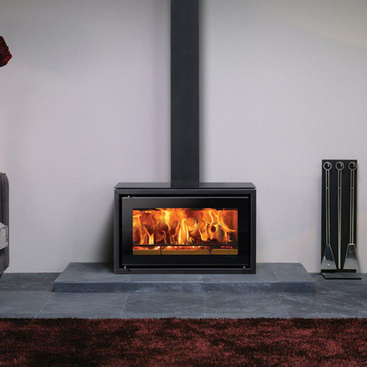 Stovax Studio 1 Freestanding wood burning stove on a hearth in a grey room — The Stove Yard