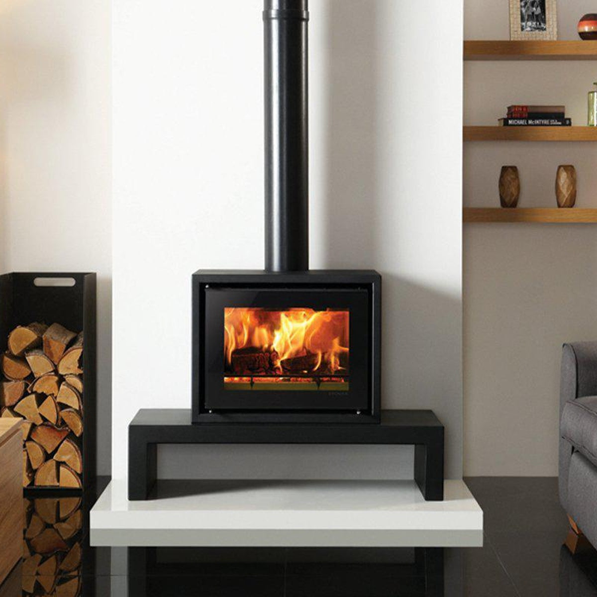 Stovax Studio 500 Freestanding wood burning stove on a 100 Low Riva Bench. Also shown: Medium log holder also available from Stovax. — The Stove Yard