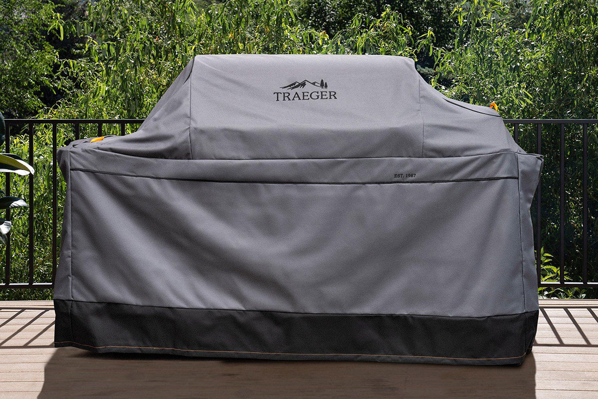 Traeger Ironwood XL grill under its grey full-length cover on an outdoor deck