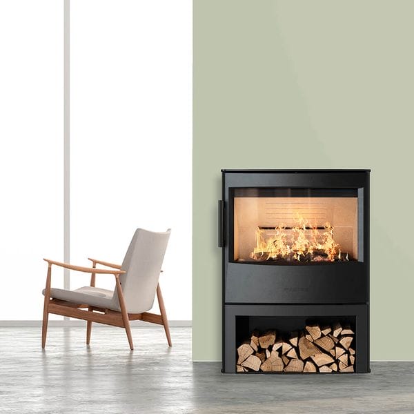 WIKING Maxi 4 with wood store beside an armchair and pale green wall