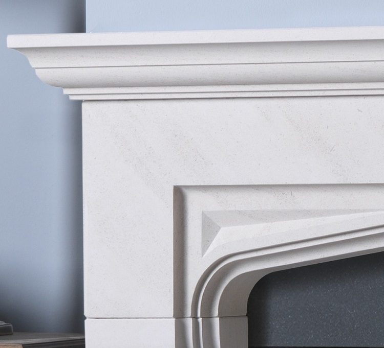 Beaufort Iberian limestone fireplace surround — carved shelf and shaped opening detail