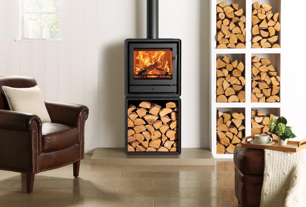 Stovax Riva2 50 freestanding fire on an optional log box beside a brown chair