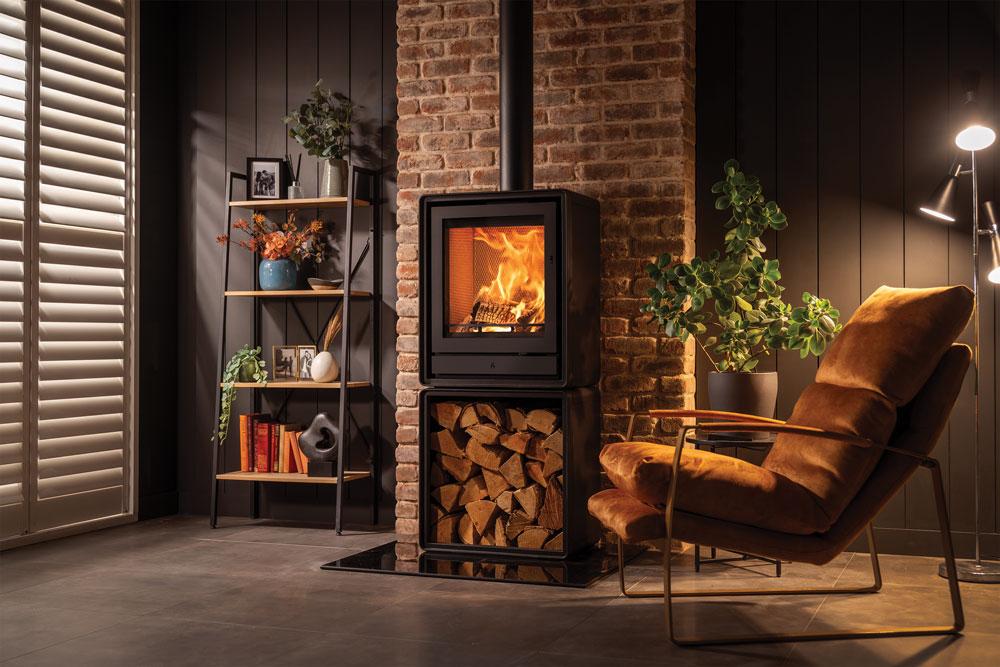 Stovax Riva2 55 freestanding fire on an optional log box beside an ochre chair