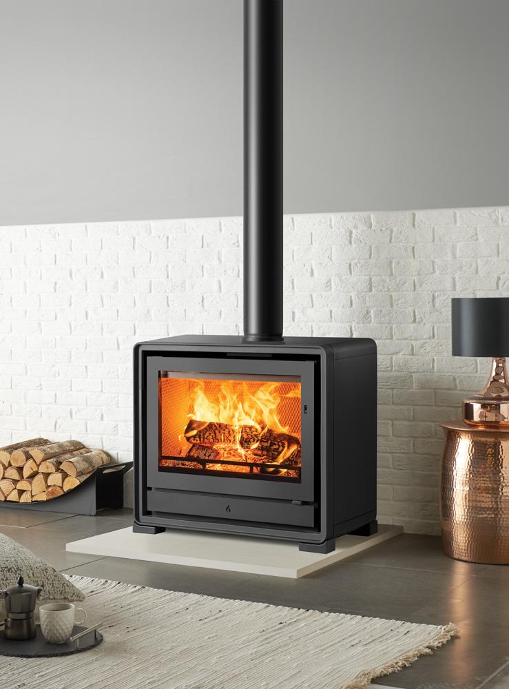Stovax Riva2 66 freestanding fire with optional cast-iron feet in a white brick-lined opening