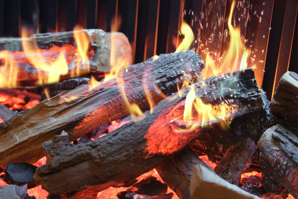 Close-up of a Solus electric fire log bed with glowing logs, flames and spark effects
