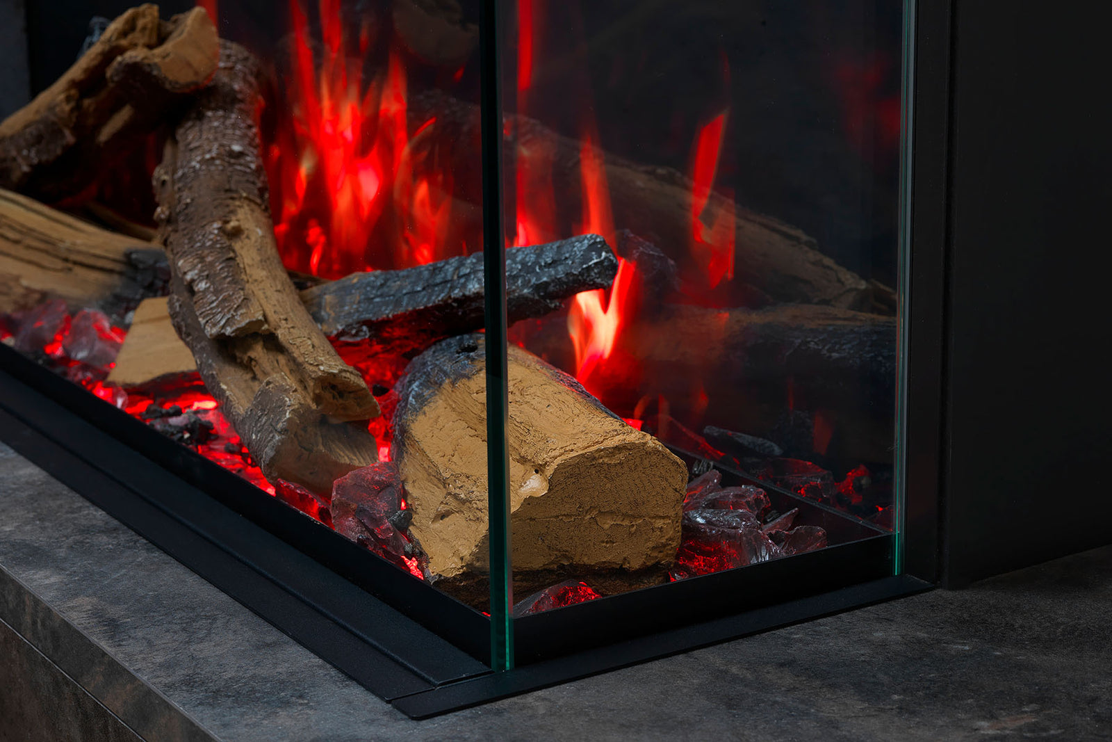 Close-up of the Solus VS75 glass corner, log bed and red flame effect