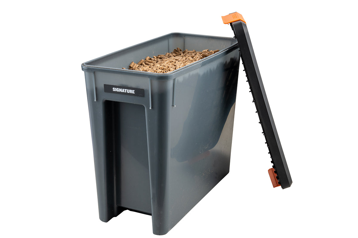 Open Traeger StayDRY bin filled with wood pellets, with its lid resting alongside