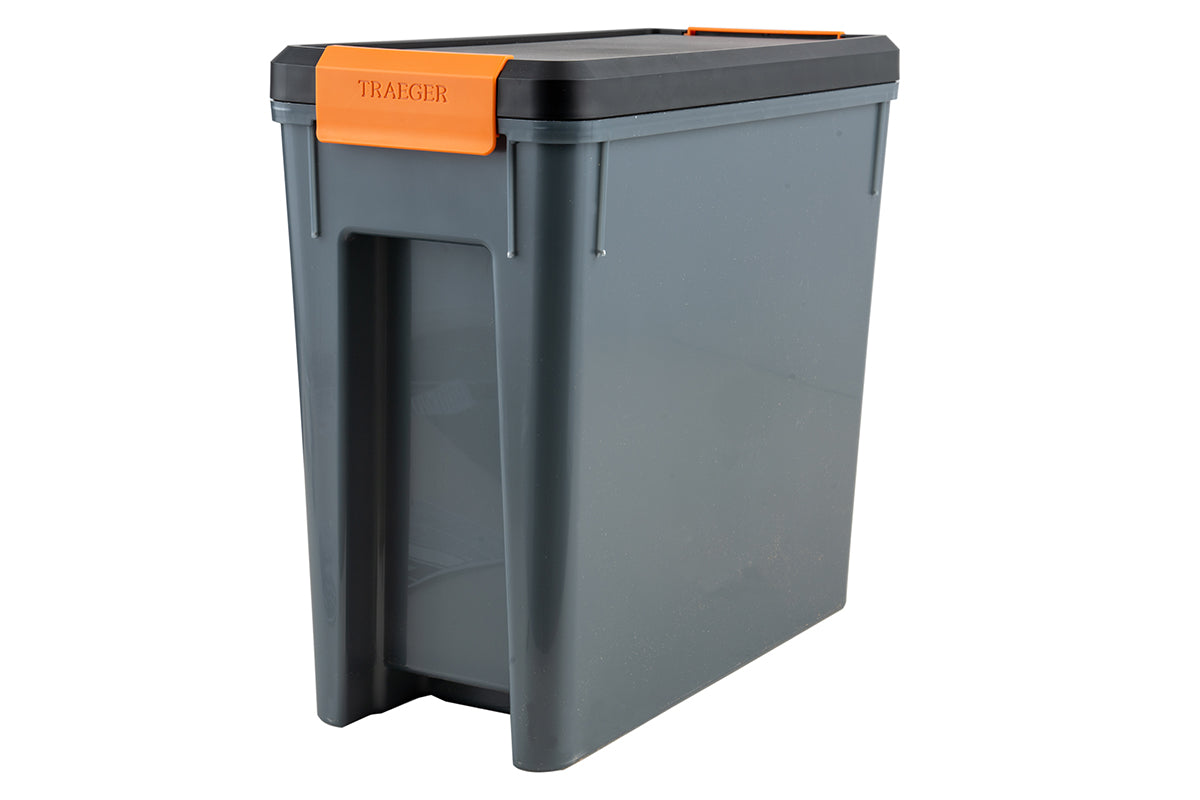 Grey Traeger StayDRY pellet bin with a black lid and orange latch, viewed at an angle