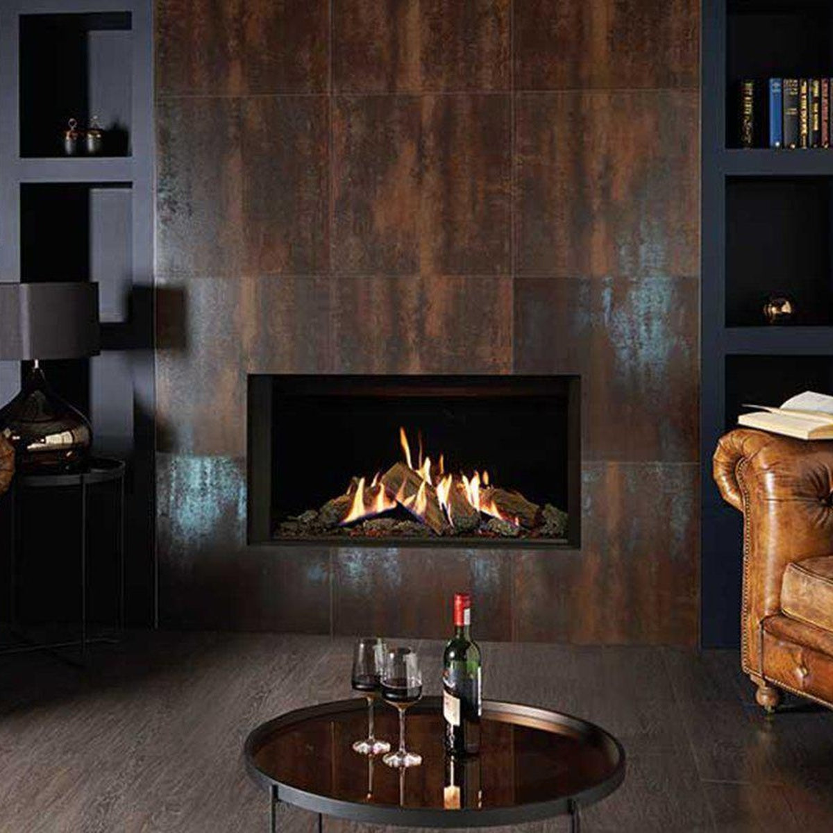 Gazco Reflex 105 Edge gas fire in a dark tiled chimney breast between leather chairs