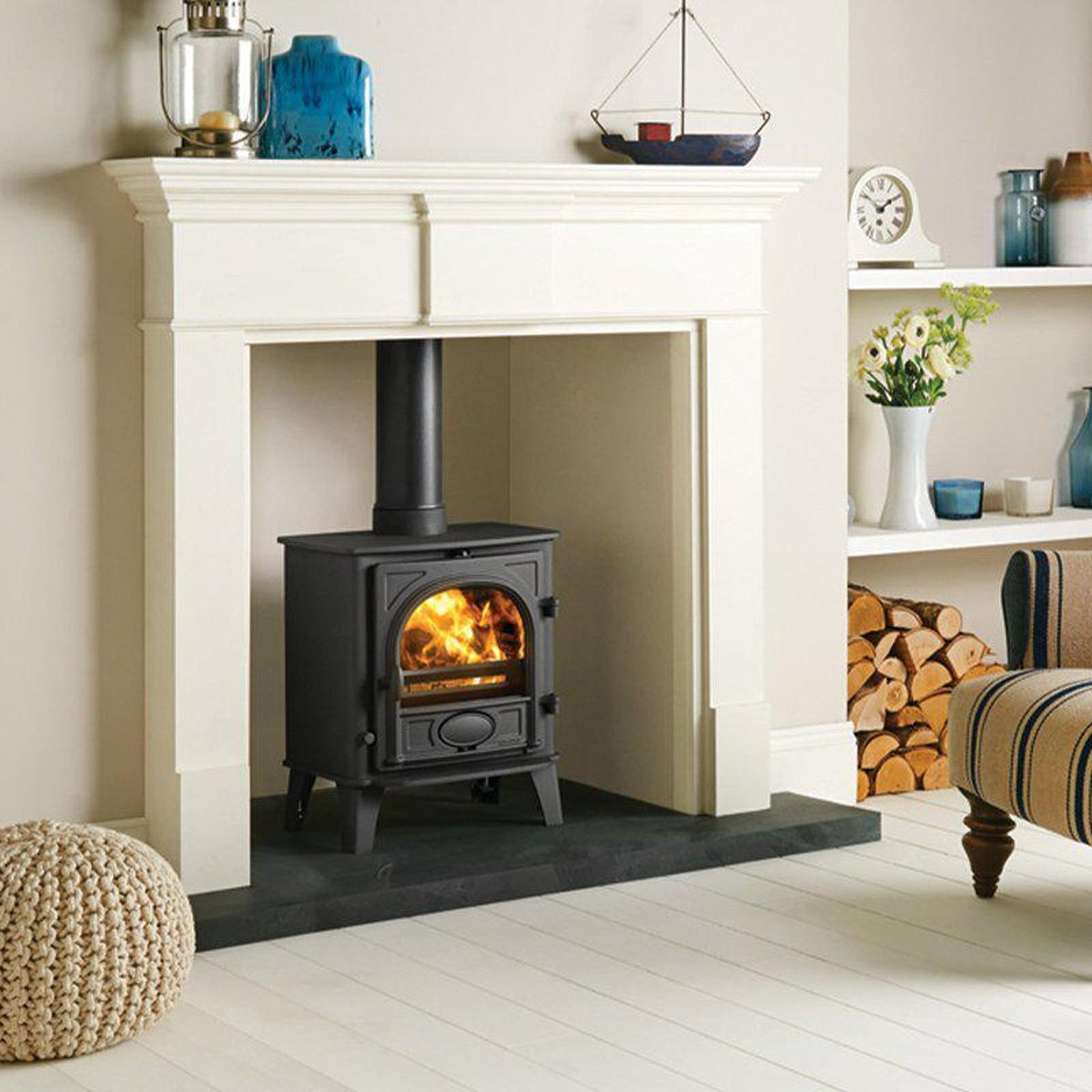 Stovax Stockton 5 Matt Black multi-fuel stove with a white mantel and striped chair