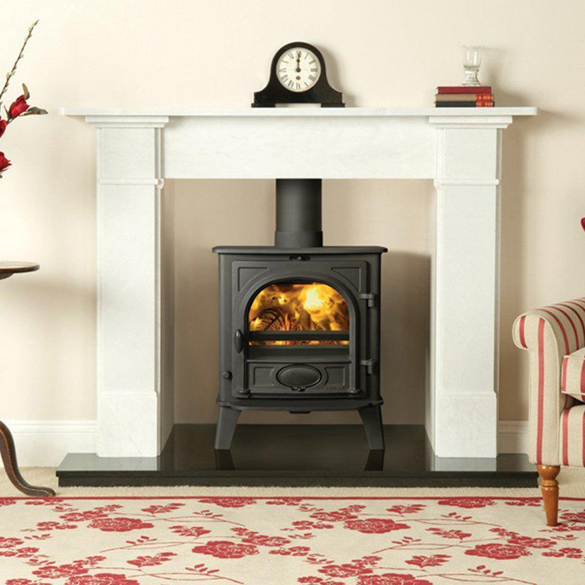 Stovax Stockton 5 Matt Black multi-fuel stove with white mantel and red striped chair