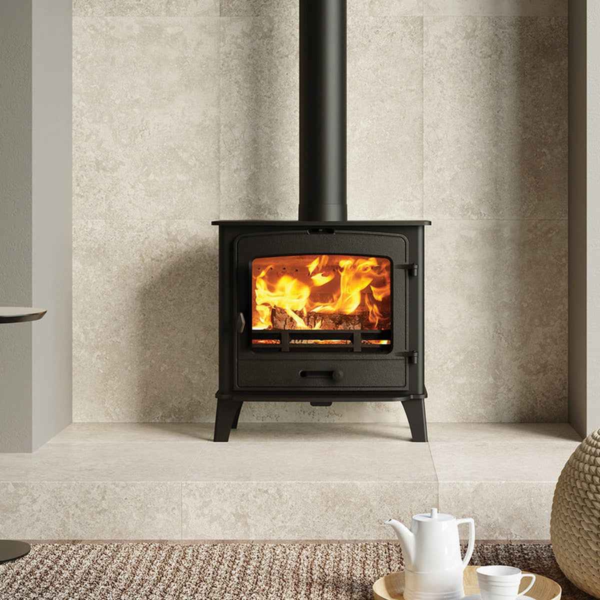 Stovax County 5 Wide stove in a pale stone fireplace against a green wall