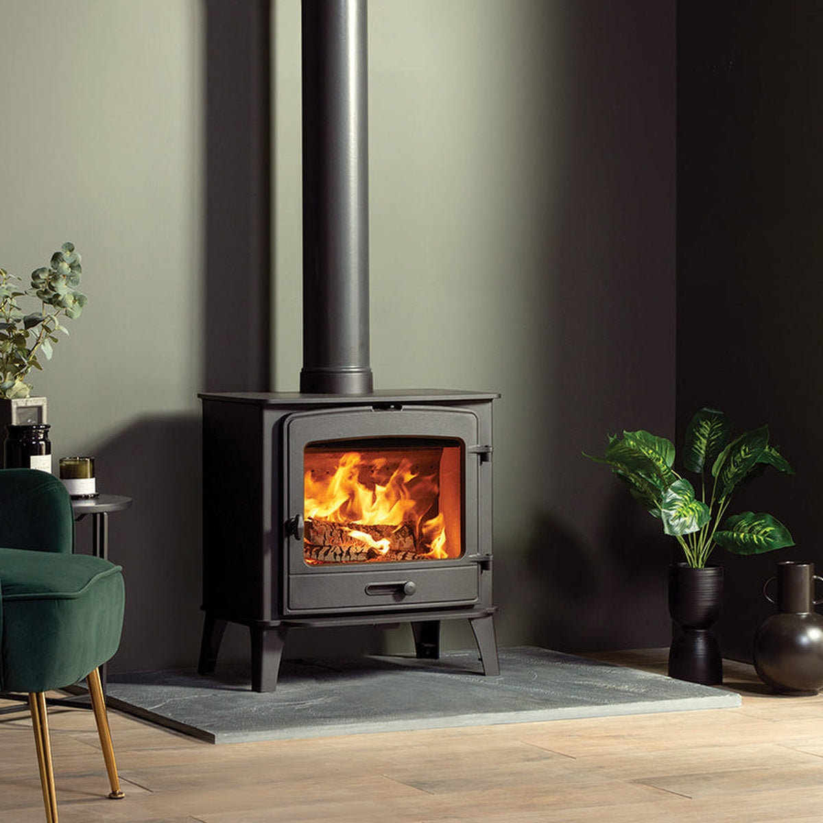 Stovax County 8 stove on a hearth between green armchairs
