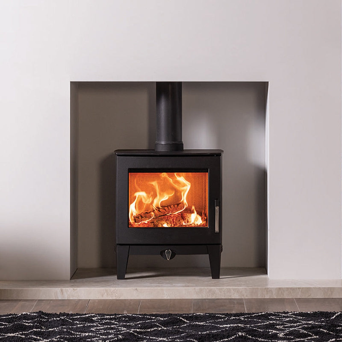 Stovax Futura 5 in a white recess beside a log store