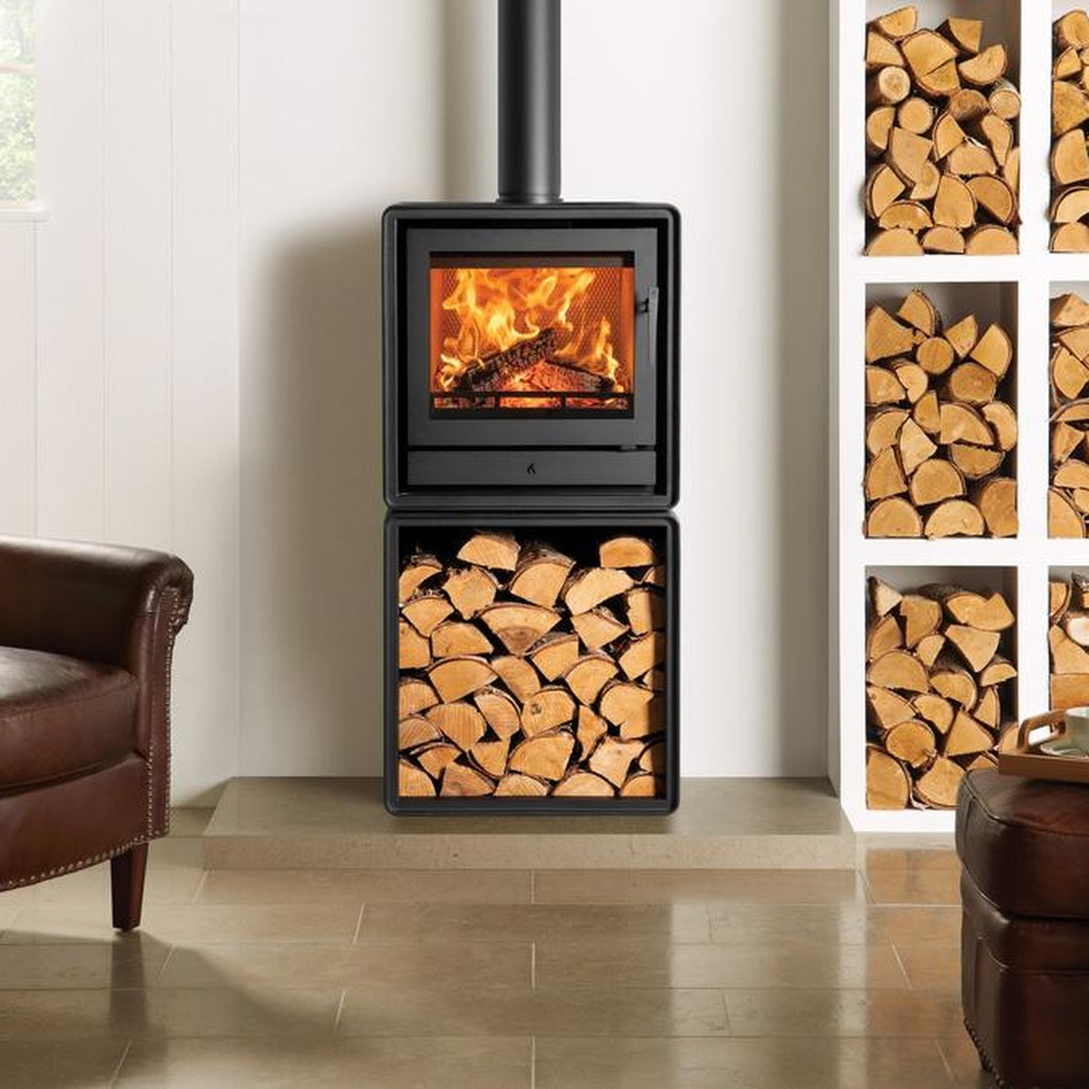 Stovax Riva2 50 freestanding fire on an optional log box beside a brown chair