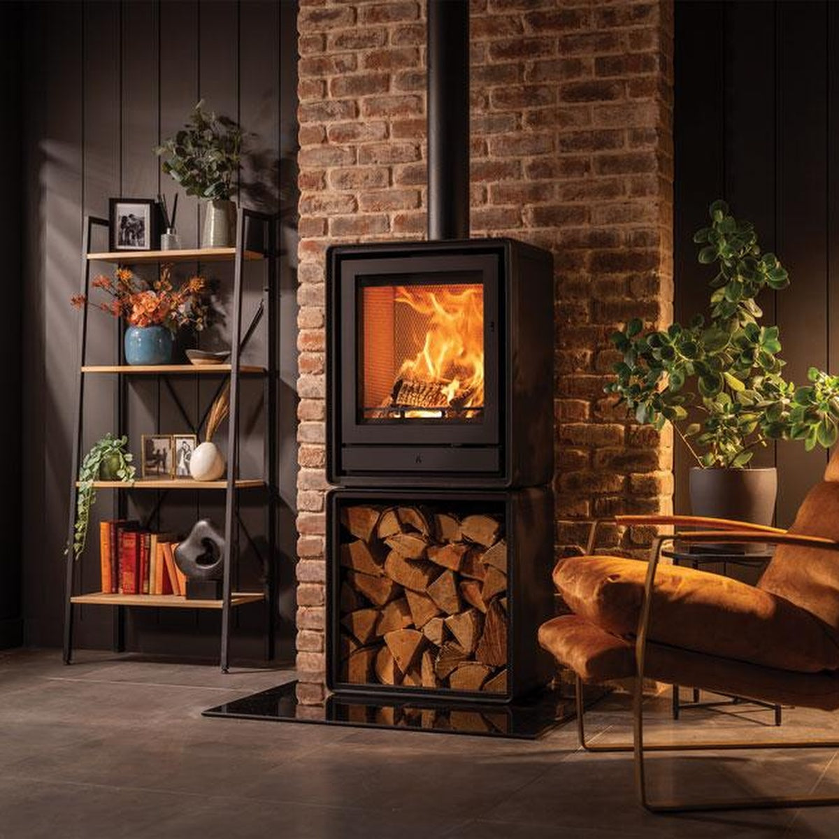 Stovax Riva2 55 freestanding fire on an optional log box beside an ochre chair