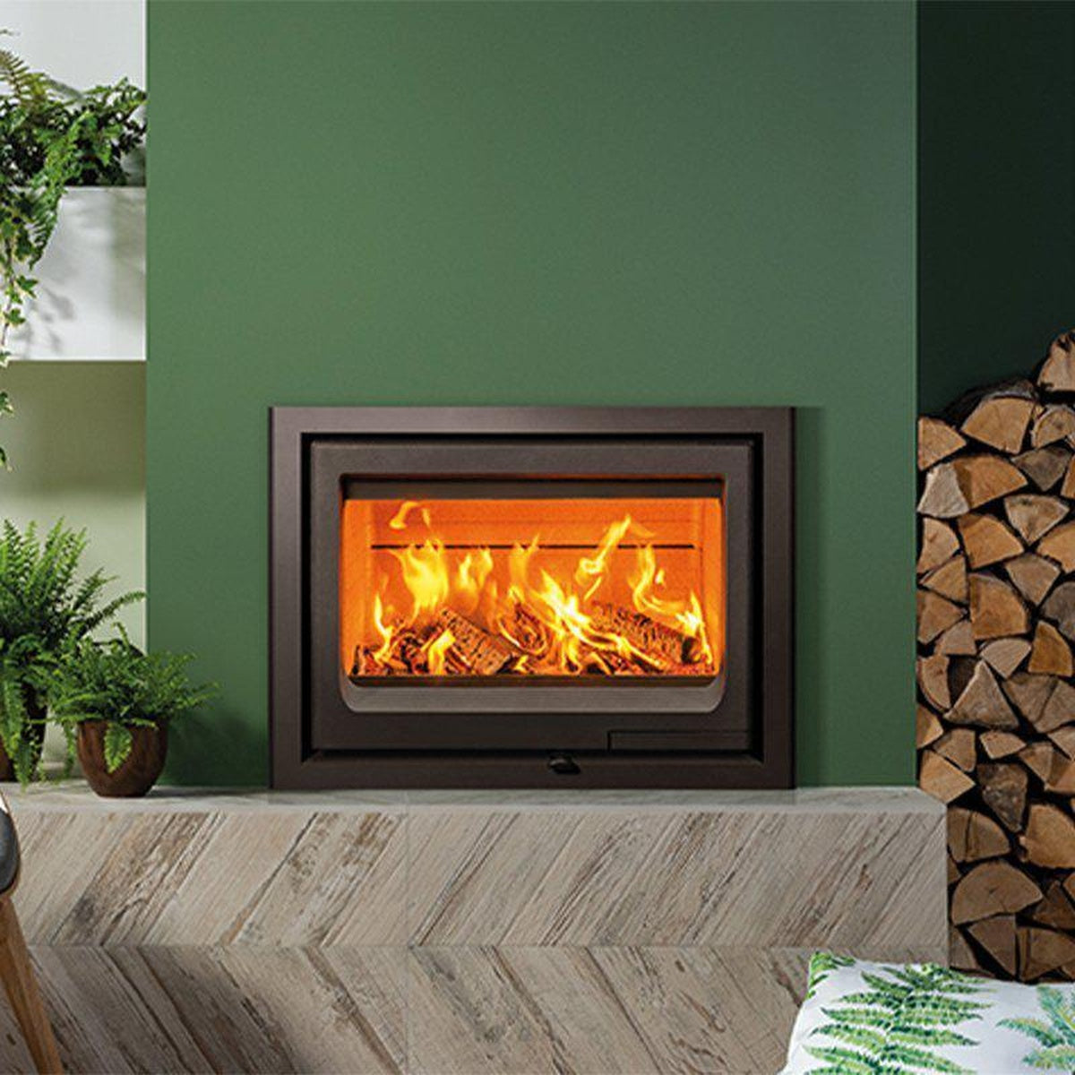 Stovax Vogue 700 Inset wood fire on a raised hearth against a green wall