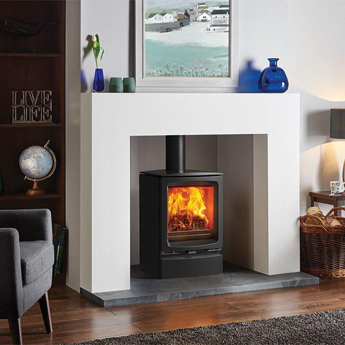 Stovax Vogue Midi stove with plinth beneath a white fireplace opening
