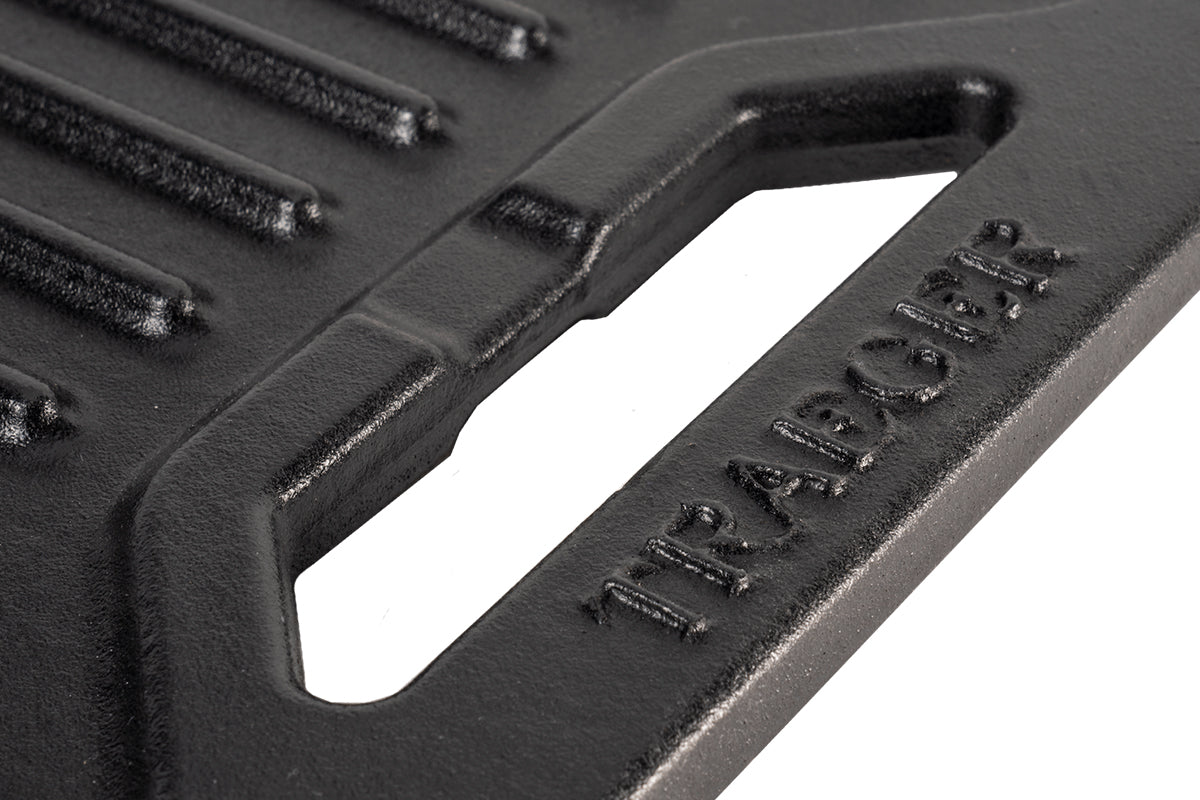 Close-up of the griddle handle with raised Traeger lettering beside the ribbed cooking surface
