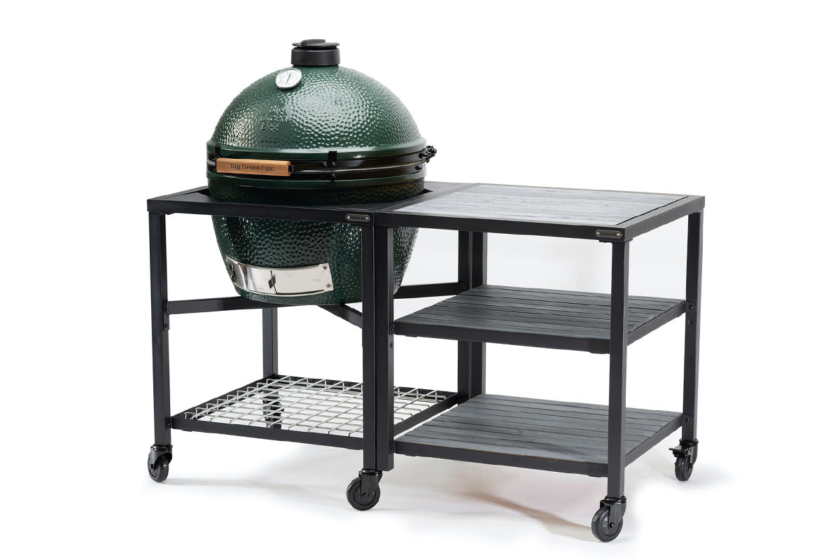 Big Green Egg in a wheeled Modular Nest beside an expansion frame with three grey acacia shelves