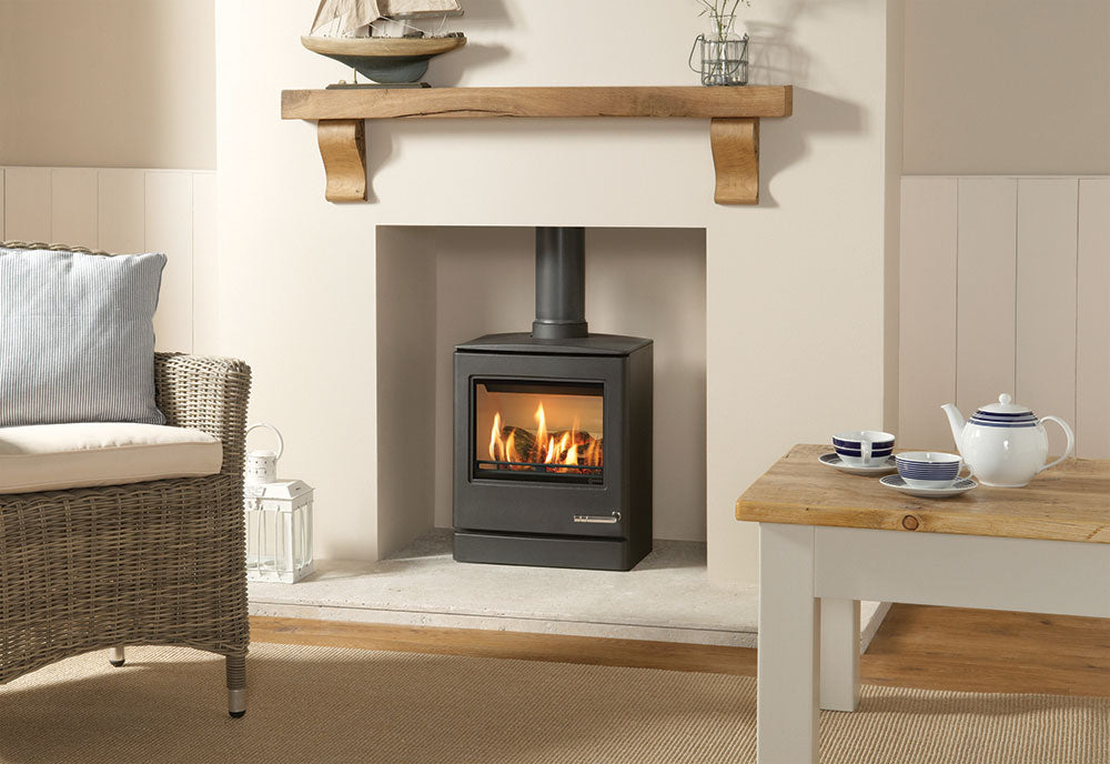 Yeoman CL5 gas stove burning in a cream fireplace recess beneath a wooden mantel