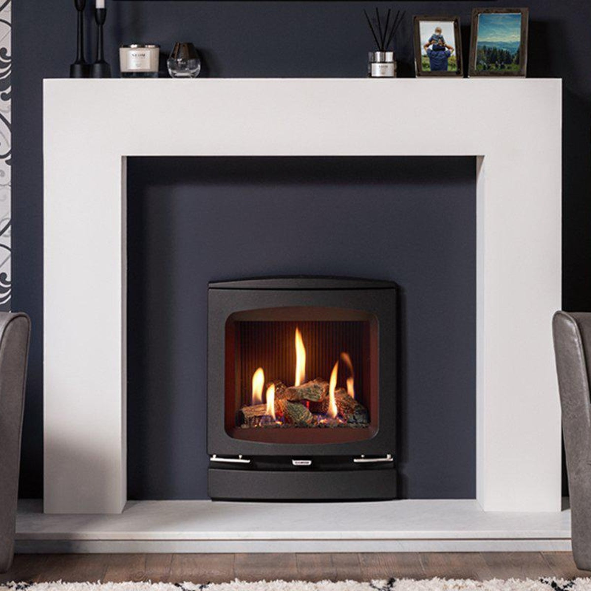 Gazco Logic HE conventional flue gas fire with log effect and Vogue Inset front, shown in a white mantel