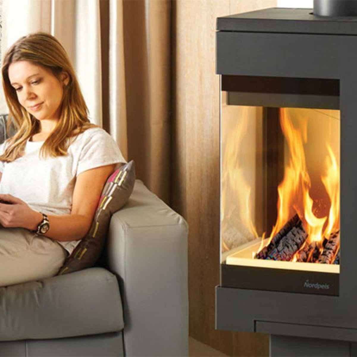 Nordpeis Quadro 1 firebox beside a seated reader