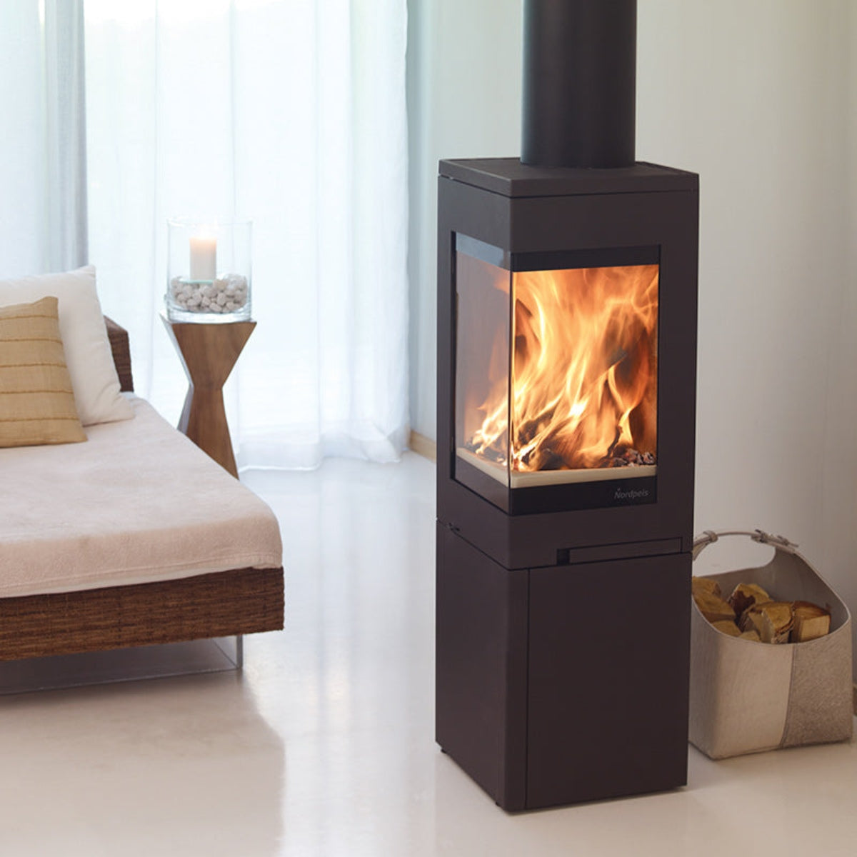 Nordpeis Quadro 2 wood stove beside a sofa
