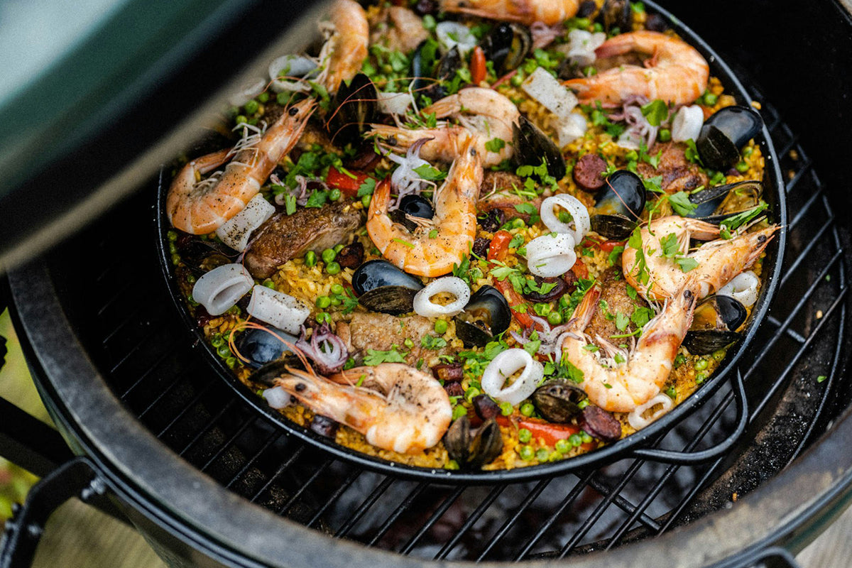 Authentic Spanish paella cooking on the Big Green Egg Paella Pan.